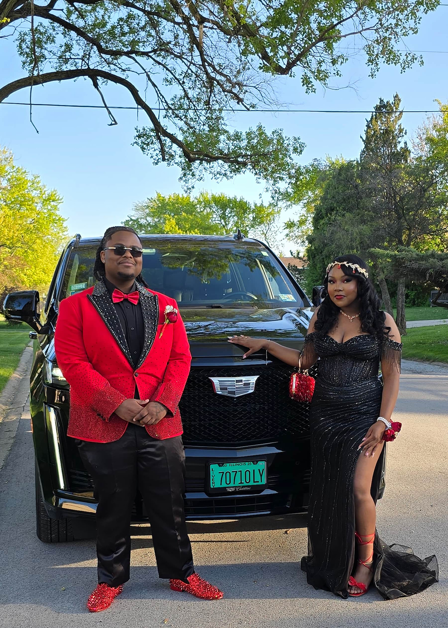 Prom couple in custom red and black MBW Collections couture in front of Cadillac Escalade